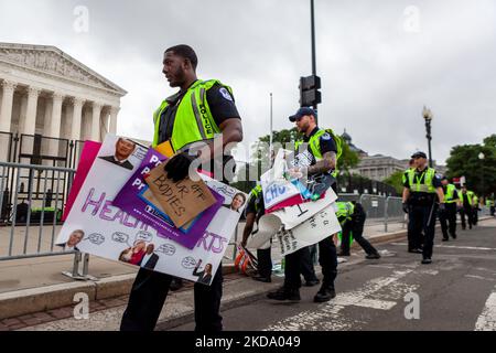 Capitol Police remove signs hung on barricades in front of the Supreme Court following the flagship event of a nationwide day of protest for reproductive rights. Hosts Planned Parenthood and the Women's March organized the numerous demonstrations in a response to the leaked draft opinion by the Supreme Court that will overturn the right to abortion established by Roe v. Wade. Millions of Americans attending the event demanded that the rights to bodily autonomy and reproductive decisions remain in the hands of each individual. (Photo by Allison Bailey/NurPhoto) Stock Photo