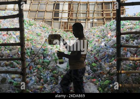 A worker collects soybean oil from recycled plastic bottle in a plastic recycling factory in Dhaka, Bangladesh on March 18, 2022. (Photo by Kazi Salahuddin Razu/NurPhoto) Stock Photo