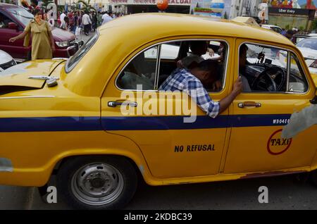 A tired passenger sleeps inside a yellow taxi in Kolkata, India, 02 June, 2022. (Photo by Indranil Aditya/NurPhoto) Stock Photo