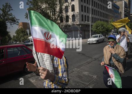 Two Iranian Basiji (Members of Basij Paramilitary force) university students carrying Iranian flags during a rally to mark the thirty-third death anniversary of Founder of the Islamic Republic, Ayatollah Ruhollah Khomeini, in downtown Tehran on June 3, 2022. (Photo by Morteza Nikoubazl/NurPhoto) Stock Photo