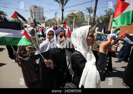 Palestinian girls wave national flags and the Holy Quran during a march to start a summer camp organized by the Hamas movement, in Gaza City, on June 04, 2022. (Photo by Majdi Fathi/NurPhoto) Stock Photo