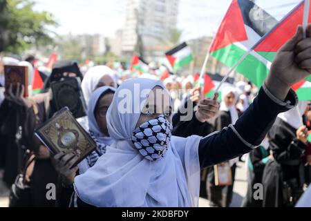 Palestinian girls wave national flags and the Holy Quran during a march to start a summer camp organized by the Hamas movement, in Gaza City, on June 04, 2022. (Photo by Majdi Fathi/NurPhoto) Stock Photo