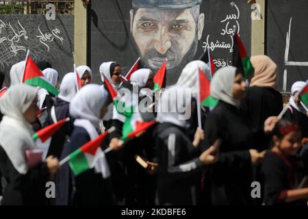 Palestinian girls wave national flags and the Holy Quran during a march to start a summer camp organized by the Hamas movement, in Gaza City, on June 04, 2022. (Photo by Majdi Fathi/NurPhoto) Stock Photo