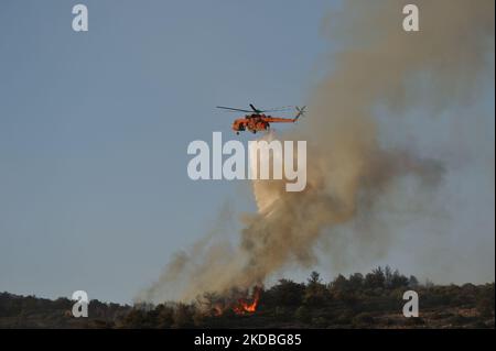 Athens, Greece. 4th June 2022. A firefighting helicopter operates in the region of Voula as wildfire blazes across the slopes of Mount Hymettus forcing authorities to evacuate residents in some areas in the southern suburbs in Athens, Greece. (Photo by Nicolas Koutsokostas/NurPhoto) Stock Photo