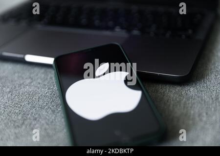 Apple logo displayed on a phone screen and a laptop are seen in this illustration photo taken in Krakow, Poland on June 6, 2022. This year's Apple Worldwide Developers Conference begins today. (Photo by Jakub Porzycki/NurPhoto) Stock Photo