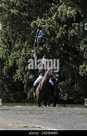 Hawick, UK. 10.Jun.2022. the Principals at the Coble Pool in the River Teviot, where they enter the water. The Cornet lowers the staff of the Flag three times into the water to mark the ancient boundary of the Burgh. Hawick Cornet 2022, Greig Middlemass, Right Hand Man, Connor Brunton [2019 Cornet], Left Hand Man, Gareth Renwick [2018 Cornet] The Hawick Common Riding is the first of the Border Common Ridings and celebrates both the capture of an English Flag, by the youth of Hawick at the military skirmish of Hornshole in 1514 and the ancient custom of riding the marches or boundaries of the c Stock Photo