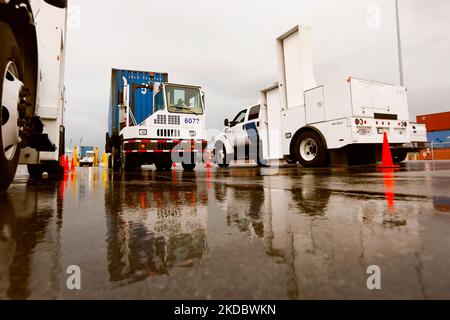A shipping container pulled by a port vehicle is scanned by truck-mounted radiation detection systems operated by U.S. Customs and Border Protection officers at the Port of Miami in Miami Fla., Dec. 07, 2015. U.S. CBP Photo by Glenn Fawcett Stock Photo
