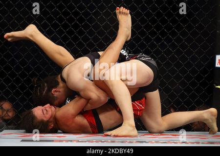 Zhang Weili of China (top) battles Joanna Jedrzejczyk of Poland in the women’s strawweight bout during the UFC 275 event at Singapore Indoor Stadium on June 12, 2022 in Singapore. (Photo by Suhaimi Abdullah/NurPhoto) Stock Photo