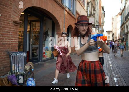 A young woman plays with a water pistol and spays passers-by. Due to a 'heat plume' coming from North Africa, France is breaking heat records especially in the south. France is 6 to 13°C above normal temperatures for June. Several heat records will be broken until the end of the heat plume. MeteoFrance says that on friday, temperatures could reach in SW of France, anywhere between 39°C and 44°C. For now, it looks like June 2022 will be the hottest June on record in France since 1850. Christophe Cassou (CNRS and IPCC) explained that without global warming, such record breaking heat events would Stock Photo