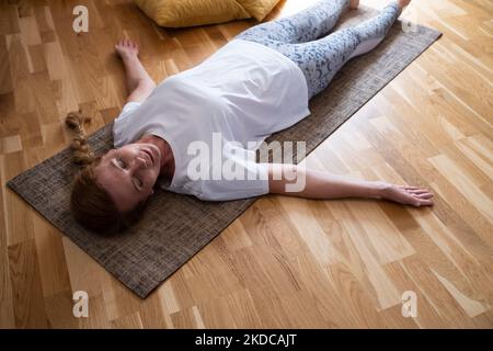 Mature caucasian woman resting after yoga practice in savasana  Stock Photo