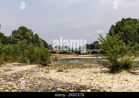 The Orco torrent, a tributary of the Po, suffering from an extreme reduction in the flow of water due to the drought is seen in the Chivasso area, in the province of Turin.The lack of water in the Po river basin has not been mitigated by the weak spring rains. After a consistent period of drought, the Po river and its basin have a water flow rate of less than half the normal. Long-term forecasts do not indicate that in the short term the weather will change with persistent precipitation. Drought is not an unusual phenomenon, but the frequency with which it recurs in recent years is also becomi Stock Photo