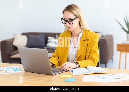 Young business woman typing on laptop keyboard, concentrated work Stock Photo