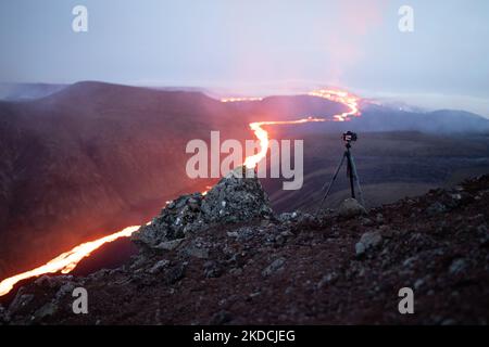 A scenic aerial shot of the erupting Fagradalsfjall volcano in Iceland with a tripod taking pictures Stock Photo