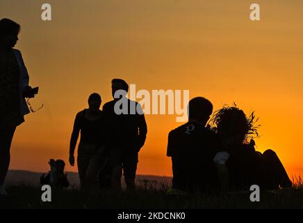 People watching the sunrise next to the Krakus Mound in Krakow. On Saturday, June 25, 2022, in Main Market Square, Krakow, Poland. (Photo by Artur Widak/NurPhoto) Stock Photo