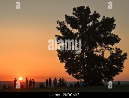 People watching the sunrise next to the Krakus Mound in Krakow. On Saturday, June 25, 2022, in Main Market Square, Krakow, Poland. (Photo by Artur Widak/NurPhoto) Stock Photo