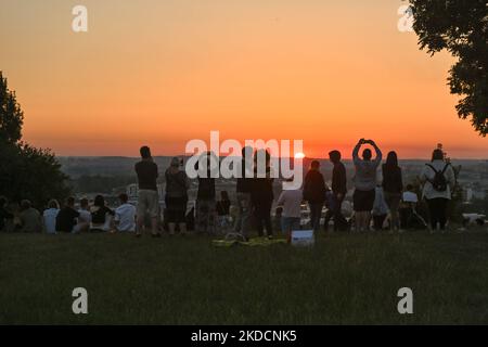 People watching the sunrise next to the Krakus Mound in Krakow. On Saturday, June 25, 2022, in Main Market Square, Krakow, Poland. (Photo by Artur Widak/NurPhoto) Stock Photo