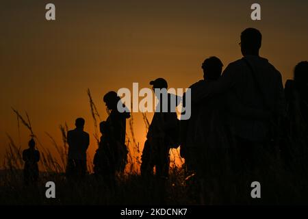 People watching the sunrise next to the Krakus Mound in Krakow. On Saturday, June 25, 2022, in Main Market Square, Krakow, Poland. (Photo by Artur Widak/NurPhoto) Stock Photo