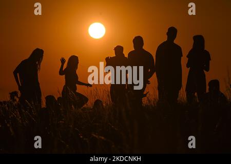 People watching the sunrise next to the Krakus Mound in Krakow. On Saturday, June 25, 2022, in Main Market Square, Krakow, Poland. (Photo by Artur Widak/NurPhoto) Stock Photo