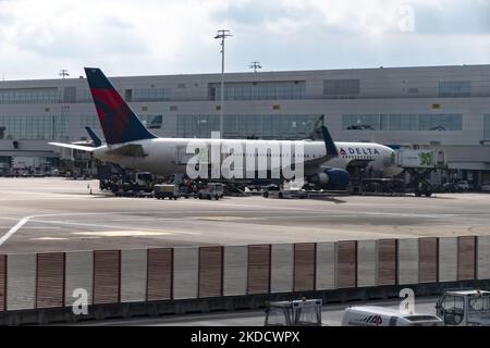 A Delta Air Lines Boeing 767 wide body jet airplane as seen in front of the airport terminal, connected to the jetbridge. US airline carriers as seen parked and connected to the airport terminal of Brussels International Airport Zaventem at the European Capital. The aircraft are unloaded and then loaded again with baggage, fuel, catering supplies etc for a turnaround to the United States of America. Many European airports suffered from flight delays and cancellations because of the staff shortage wave and the strikes during the busy summer travel season with increased demand for air travel, a  Stock Photo
