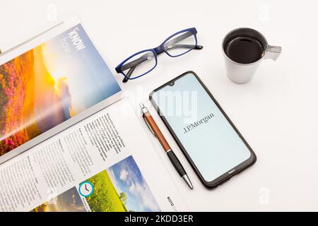 In this photo illustration a JPMorgan Chase logo seen displayed on a smartphone screen on a desk next to a cafe, a pen, glasses and a magazine in Athens, Greece on July 2, 2022. (Photo illustration by Nikolas Kokovlis/NurPhoto) Stock Photo