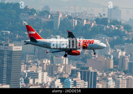 An Airbus A319 making the turn to land at Santos Dumont Airport, Rio de Janeiro, with downtown in the background, a sunny day, upper view Stock Photo