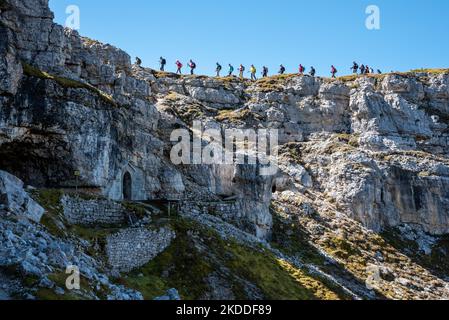 Remains of military tunnel on Mount Piano in the Dolomite Alps, built during the First World War, a group of hikers passing by Stock Photo