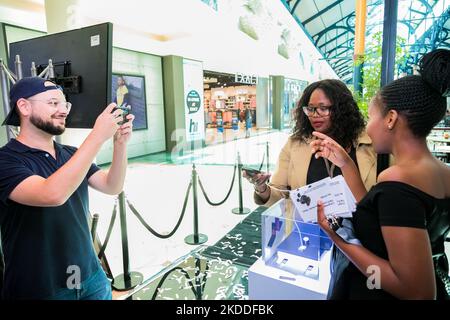The customers viewing Samsung phones at mall pop-up retail stand Stock Photo