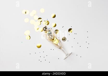 gold confetties and confetties on a white surface with confetties scattered around it Stock Photo