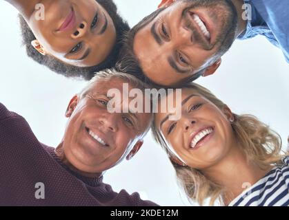 Four times the mind power. Low angle shot of a team of colleagues huddled together in unity. Stock Photo