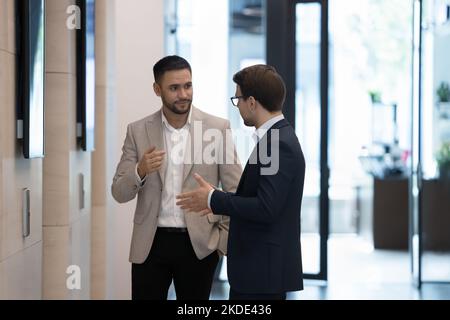Two colleagues talking meet in office hallway during break Stock Photo