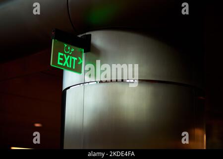 Looking for a way out. Low angle shot of an exit sign against a column in a parking garage. Stock Photo