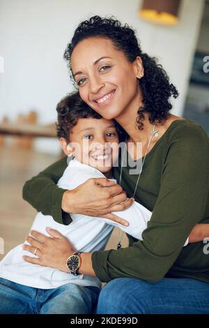 Showering her little one in endless love and care. Portrait of a mother hugging her little son at home. Stock Photo