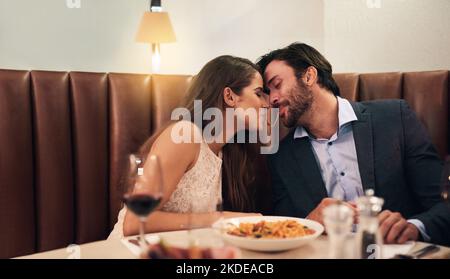 Hes my kinda guy. a young couple sharing spaghetti during a romantic dinner at a restaurant. Stock Photo