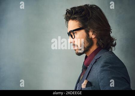 Hes a profile of style. Studio profile shot of a stylishly dressed handsome young man wearing glasses. Stock Photo