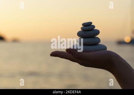 Zen stones background. Tower of stones on the sea beach on a summer evening. Meditation, calmness, peace, mental health concept. High quality photo Stock Photo