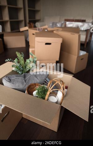 Vertical view stuffed with belongings cardboard boxes stacked on floor Stock Photo