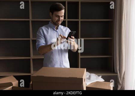 Young man using smartphone on relocation day Stock Photo