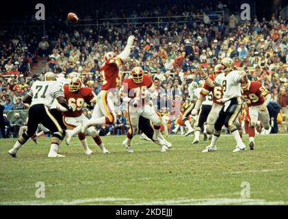 New Orleans Saints quarterback Archie Manning (8) throws a pass under heavy pass rush by the Washington Redskins during the game at Robert F. Kennedy Stadium in Washington, DC on October 28, 1979. Also pictured are Saints offensive tackle J.T. Taylor (71) and Redskins defenders Perry Brooks (69), left defensive end Karl Lorch (71), right defensive end Coy Bacon (79), left defensive tackle Dave Butz (65), and left linebacker Brad Dusek (59). The Saints won the game 14 - 10. Credit: Arnie Sachs/CNP Stock Photo