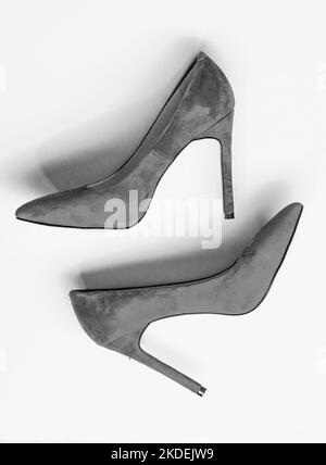 Luxury footwear concept. Footwear with thin high heels, stiletto shoes, top view. Shoes made out of red suede on yellow background. Pair of Stock Photo