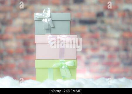 Colored gift box presents on white snow, background brick wall Stock Photo