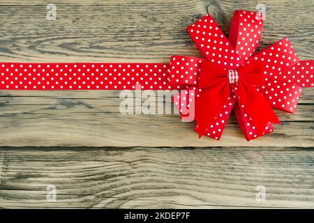 Red ribbon with white dots on wooden background Stock Photo