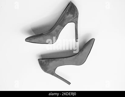 Feminine shoes concept. Footwear with thin high heels, stiletto shoes, top view. Shoes made out of red suede on yellow background. Pair of fashionable Stock Photo
