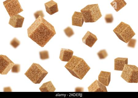 Falling Brown cane sugar cubes isolated on white background, selective focus Stock Photo