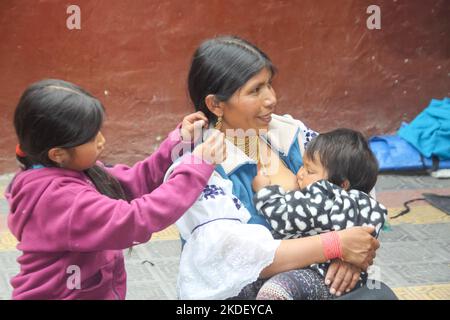 Quechua Mother and Children at the Traditional handicraft market at Otavalo, Imbabura Province, Ecuador. Stock Photo