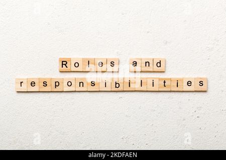 roles and responsibilities word written on wood block. roles and responsibilities text on table, concept. Stock Photo