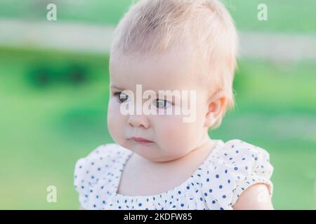 adorable baby in polka dot dress in the park Stock Photo