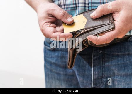 Close-up of a man's hand taking out a credit card from a personal document holder or wallet. Stock Photo