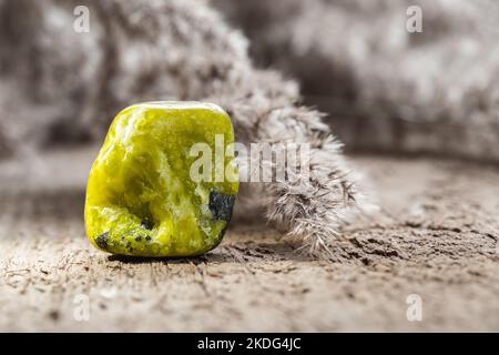 Polished Yellow Lizardite or Norwegian Jade Mineral Gemstone Specimen on Wooden Background Stock Photo