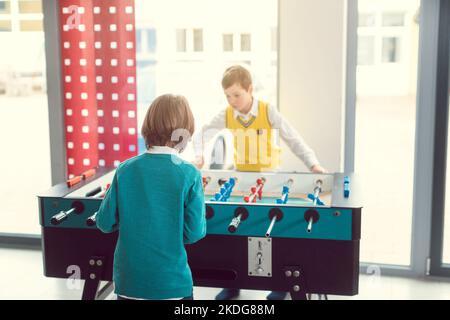 Two boys in school break playing tabletop football Stock Photo
