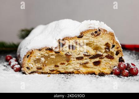 Traditional German Christmas stollen with fruit and nuts cut on a black plate Stock Photo